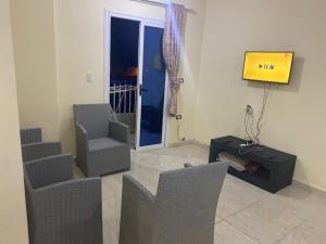 a living room with three chairs and a tv at شقه مصيف للايجار بكمبوند عجيبه سيتي مرسي مطروح in Zâwyet Umm el Rakham