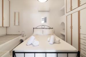 um quarto branco com uma cama com toalhas em Platis Gialos beach house with sea view balcony em Platis Gialos, Mykonos