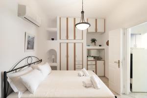 a white bedroom with a bed with white pillows at Platis Gialos beach house with sea view balcony in Platis Gialos