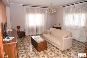 a living room with a couch and a table at Casa Montegrappa - tra Etna e Mare Parcheggio gratuito in Zafferana Etnea