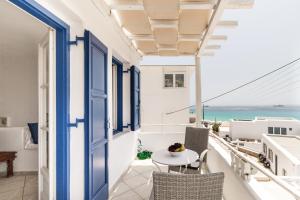 uma varanda com uma mesa e cadeiras e o oceano em Platis Gialos beach house with sea view balcony em Platis Gialos, Mykonos