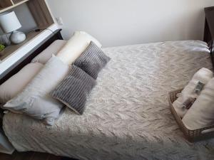 危地馬拉的住宿－Narama Luxury near to the airport，一张带白色枕头的床和一个篮子