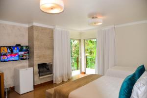 a bedroom with a bed and a fireplace at Pousada do Lago Penedo in Penedo