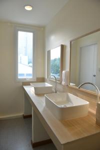 a bathroom with two sinks and a large mirror at PanPan Hostel in Bangkok