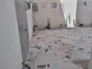 patio z podłogą wyłożoną kafelkami i butelką wody w obiekcie Maison brahim w mieście Agadir