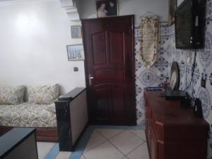 salon z kanapą i czerwonymi drzwiami w obiekcie Maison brahim w mieście Agadir