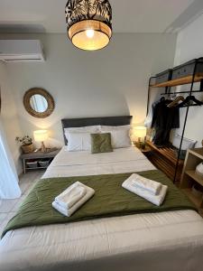 a bedroom with a large bed with two towels on it at Light Blue in Perea