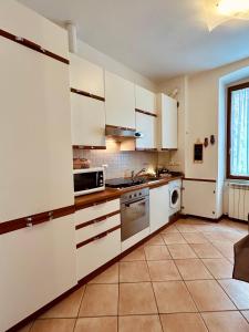 una grande cucina con armadi bianchi e una finestra di Blu Trieste a Trieste