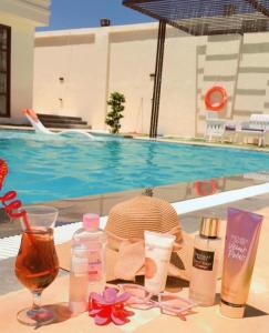 a table topped with cosmetics next to a swimming pool at Tixos Farm in Irbid