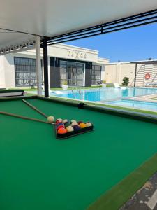 a green pool table with balls on top of it at Tixos Farm in Irbid