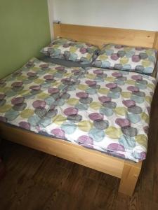 a bed with a comforter on it in a room at U Rozlitýho mlíka in Chvaleč