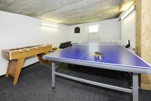 una sala de ping pong con mesa de ping pong púrpura en Aktiv-Ferienwohnungen Montafon, en Sankt Gallenkirch