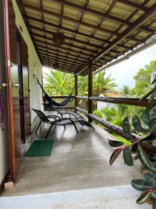 a porch with a hammock on a house at Quarto próximo a Guarajuba in Camaçari