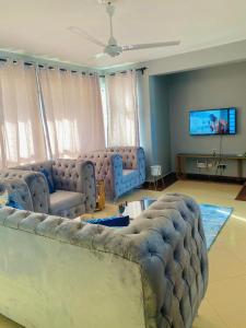 a living room with a large couch and a flat screen tv at Danmic in Mombasa