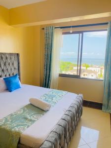 a bedroom with a bed with a large window at Danmic in Mombasa