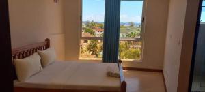 a bed in a room with a large window at Danmic in Mombasa