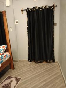 cortina negra en una habitación con cama en Opaque gardens en Tezo
