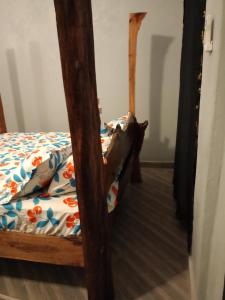 ein Schlafzimmer mit einem Bett mit einem Holzrahmen in der Unterkunft Opaque gardens in Tezo