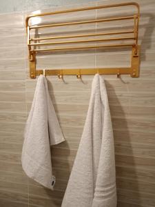 2 asciugamani appesi a un portasciugamani in bagno di Opaque gardens a Tezo