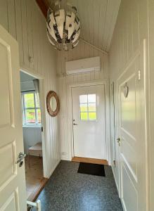 a hallway with a white door and a chandelier at Fjord road in Hjelmeland