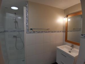 ein Bad mit einer Dusche und einem Waschbecken in der Unterkunft Gîte vallée du denacre entre terre et mer in Wimille