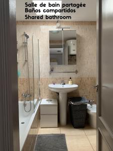 y baño con lavabo, aseo, lavamanos y ducha. en Bedroom with shared bathroom and swimming pool en Corralejo
