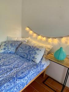 a bed with a blue and white comforter and lights on it at La stanza di Campagna in Campiglia Marittima