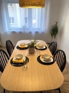 ein Holztisch mit Stühlen und Essen darauf in der Unterkunft 3 Zimmer Apartment - Nähe Klinikum & Altstadt - Parken, WLAN, Waschmaschine in Amberg