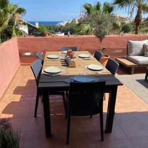 drewniany stół i krzesła na patio w obiekcie Penthouse Majestic Costa Golf Casares w mieście Casares