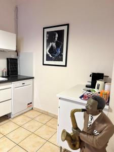 Eine Statue eines Mannes, der in einer Küche auf einem Stuhl sitzt. in der Unterkunft La Suite de la Cathédrale in Narbonne