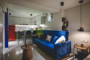 a living room with a blue couch and a kitchen at MASTER ROSE STUDIO in old town in Nafplio