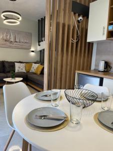 un tavolo bianco con piatti e bicchieri in cucina di Sun & Stone House a Polykhrono