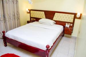 a bedroom with a bed and a phone in it at Detim Hotel in Mbalala +3 photos