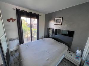 1 dormitorio con cama blanca y ventana en Naturistecapdagde Villa Port Venus Serenity, en Cap d'Agde