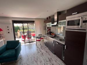 cocina con fregadero, mesa y microondas en Naturistecapdagde Villa Port Venus Serenity, en Cap d'Agde