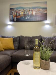 una bottiglia di vino e un bicchiere su un tavolo di Sun & Stone House a Polykhrono Altre 10 foto