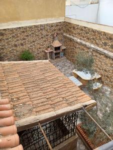 a patio with a wooden picnic table and a brick wall at MAISON DE VACANCE in Mostaganem