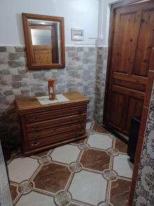 MAISON DE VACANCE في Mostaganem: حمام مع خزانة خشبية ومرآة