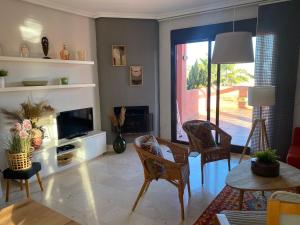 salon z telewizorem, stołem i krzesłami w obiekcie Penthouse Majestic Costa Golf Casares w mieście Casares