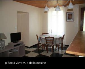 a dining room with a table with chairs and a tv at Appartement en Cévennes in Rochessadoule