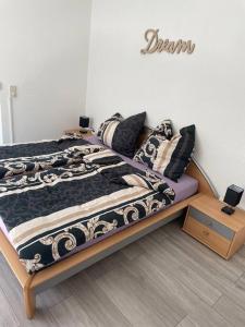 a bedroom with a bed with a black and white comforter at Sofi Wohnung in Reutlingen