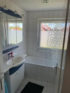a bathroom with a tub and a sink and a window at Sofi Wohnung in Reutlingen
