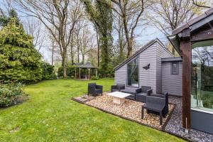BakkeveenにあるVakantiewoning De Vlinder, Bakkeveenの庭にベンチと椅子が置かれた小さな家