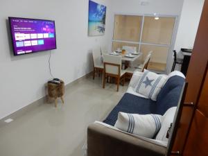 un soggiorno con divano e tavolo di Casa sobrado 7 a Guarujá