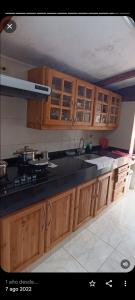 une cuisine avec des placards en bois et un comptoir noir dans l'établissement FINCA DELFOS UN PARAISO A 15 MINUTOS DE BOGOTÁ, à La Calera