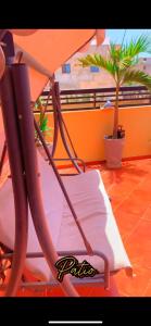 a chair and an umbrella on a balcony at Chez Anta in Dakar