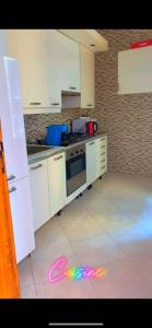 a kitchen with white cabinets and a stove top oven at Chez Anta in Dakar