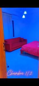 a room with two red beds and blue lights at Chez Anta in Dakar