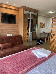 a living room with a couch and a television at Vista da Pedra Flat in Pedra Azul