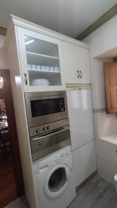 a kitchen with a washing machine and a microwave at Algarabiastaying 1 Cristeta in Medina de Pomar